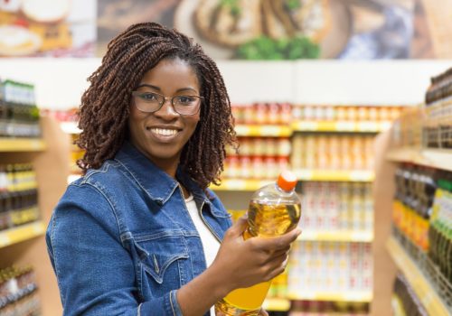 smiling-young-customer-holding-bottle-oil